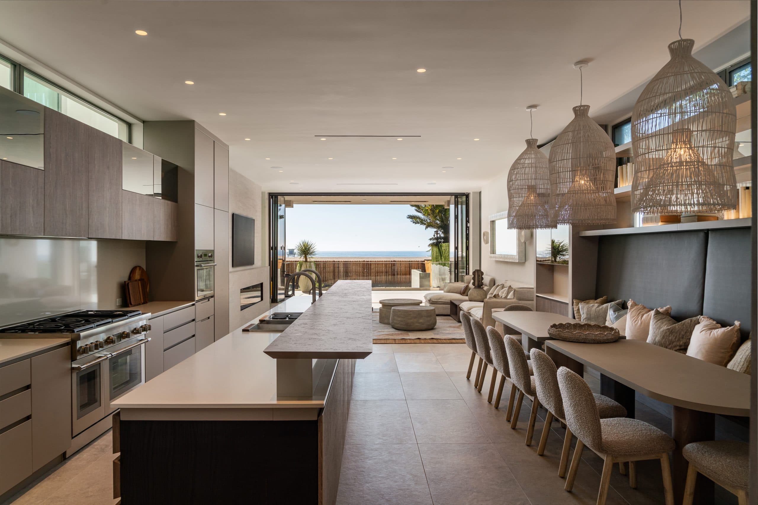 Open concept kitchen and living area with ocean views through folding glass doors