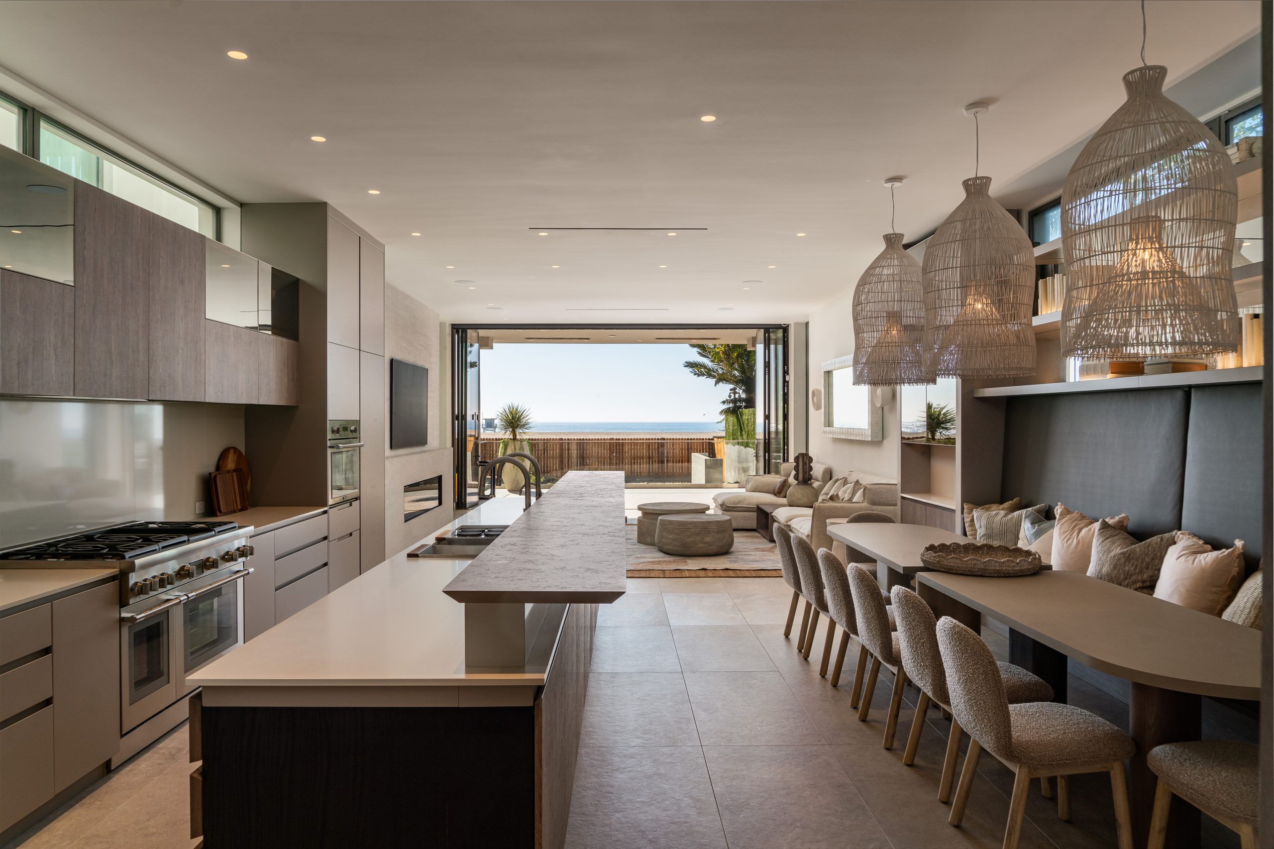 Open concept kitchen and living area with ocean views through folding glass doors